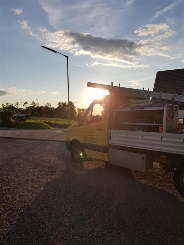 Ein gelber Lieferwagen steht bei Sonnenuntergang am Straßenrand