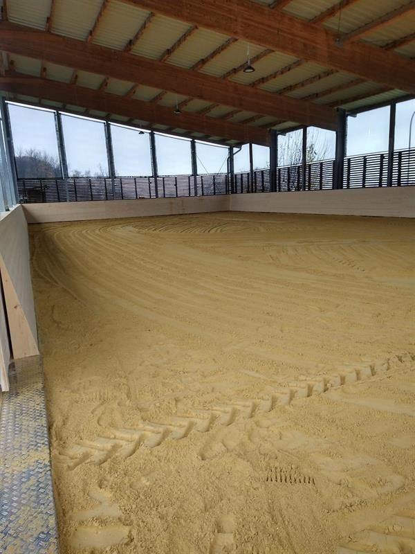 Eine große Indoor-Arena mit viel Sand darin.