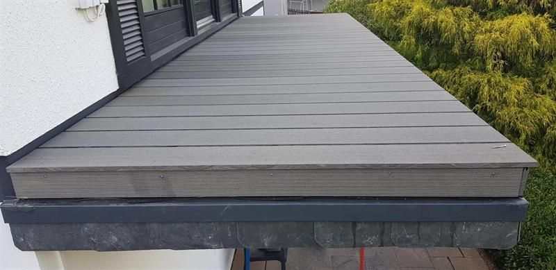 An der Seite eines Gebäudes befindet sich ein Holzdeck.