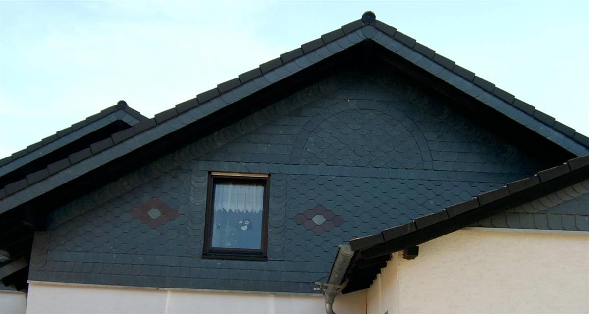 Ein Haus mit einem schwarzen Dach und einem Fenster