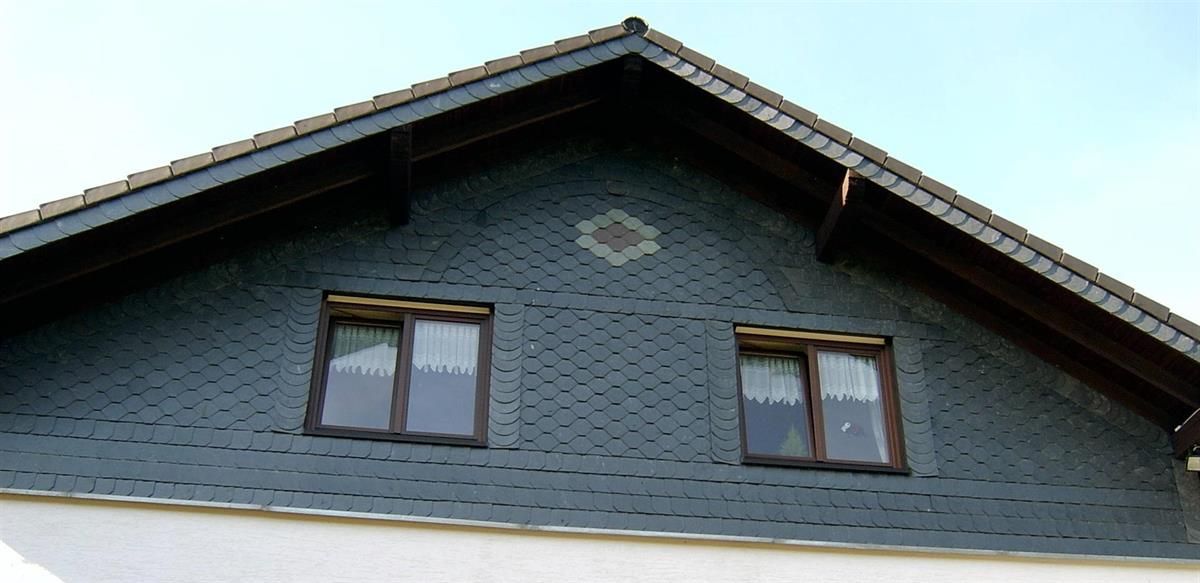 Das Dach eines Hauses mit zwei Fenstern