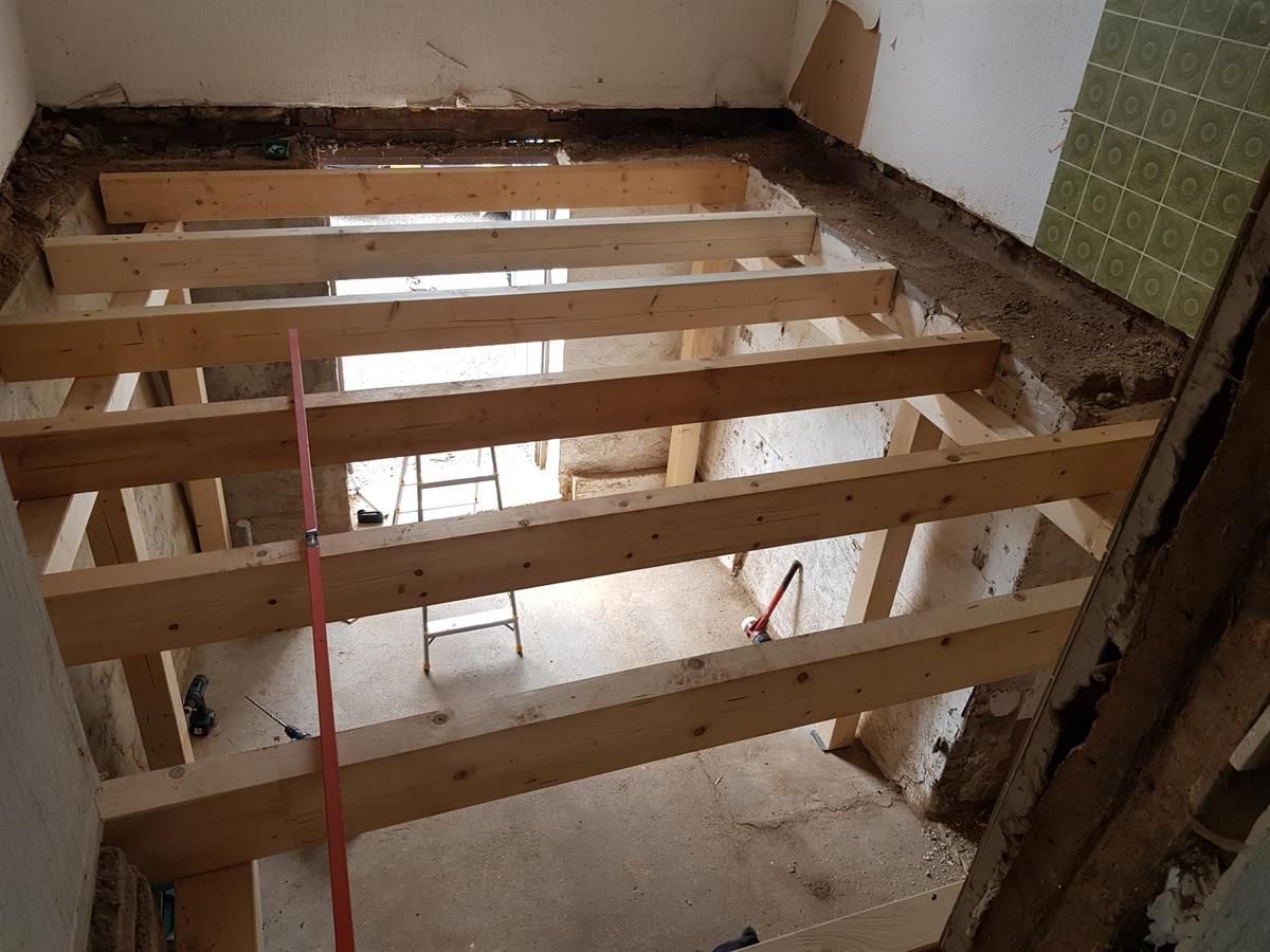 Ein im Bau befindlicher Raum mit Holzbalken und einer Leiter.