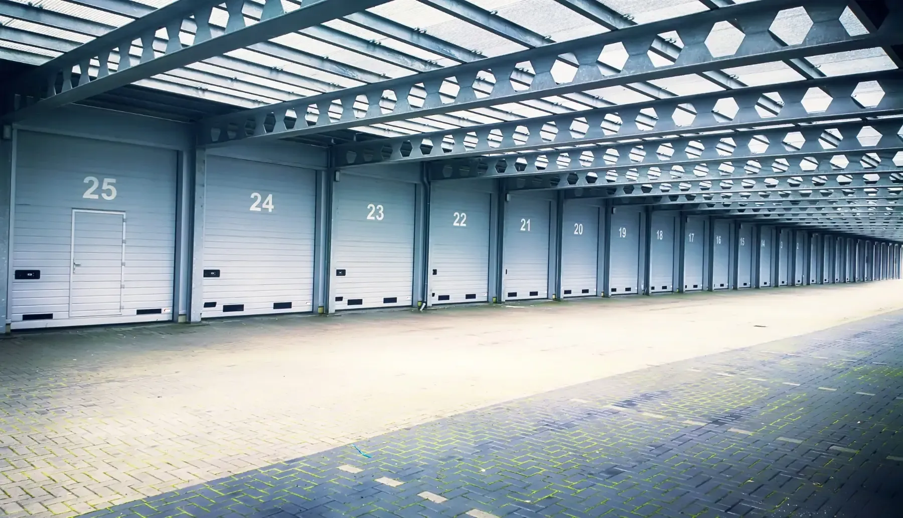 Fila de puertas numeradas de muelle de carga en un gran edificio industrial, vistas desde el interior.