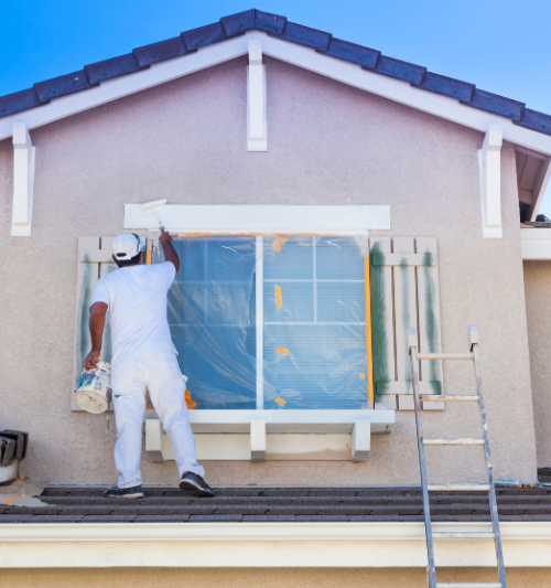 Peintre en blanc peignant l'extérieur d'une maison, fenêtre recouverte, échelle, journée ensoleillée.
