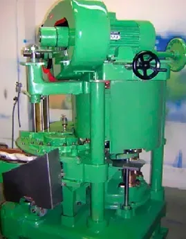 Una máquina verde con una rueda negra está sentada en una habitación.