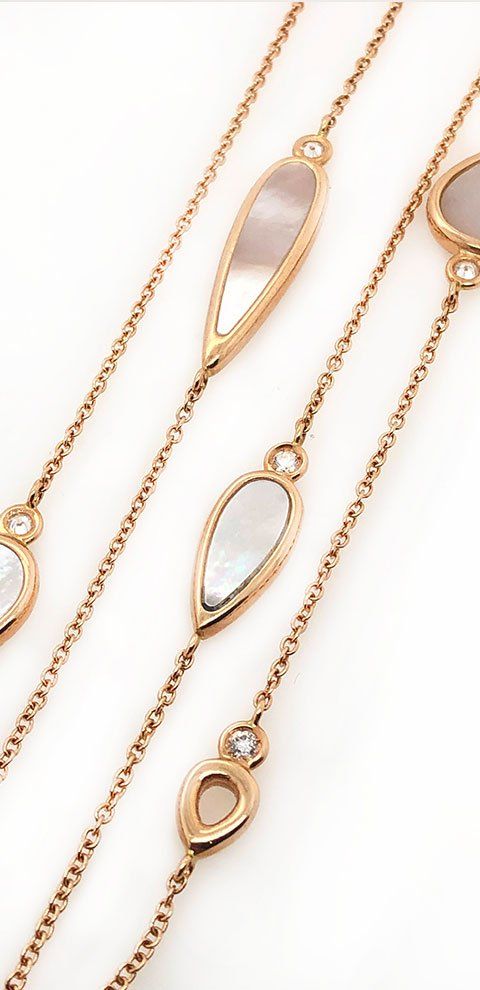 Colliers en or rose avec des accents de nacre et de diamants sur fond blanc.
