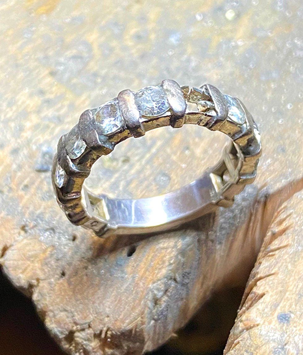 Bague en argent avec diamants taillés de manière irrégulière, sertis sur un établi.