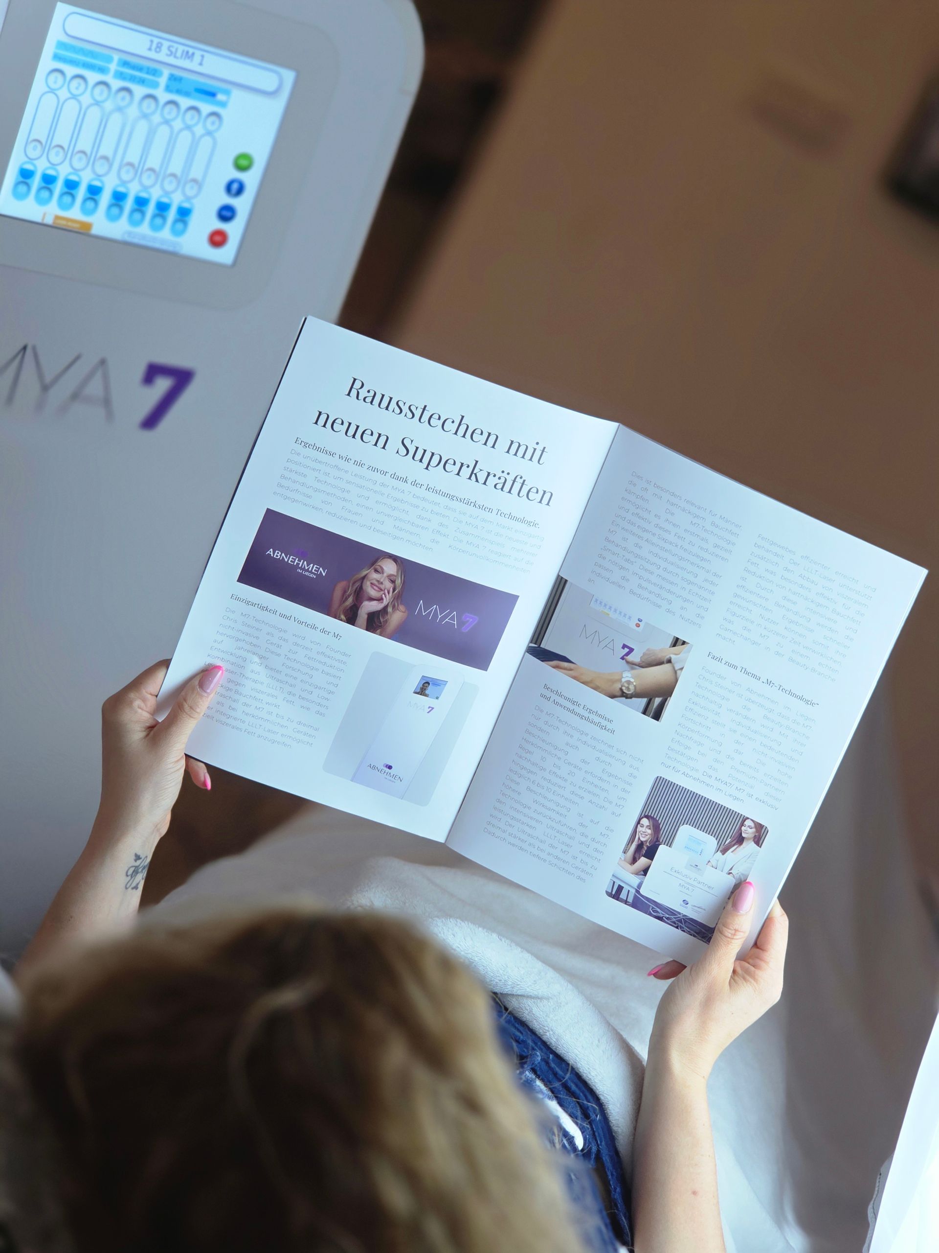 eine Frau blättert in einem Flyer über MYA7