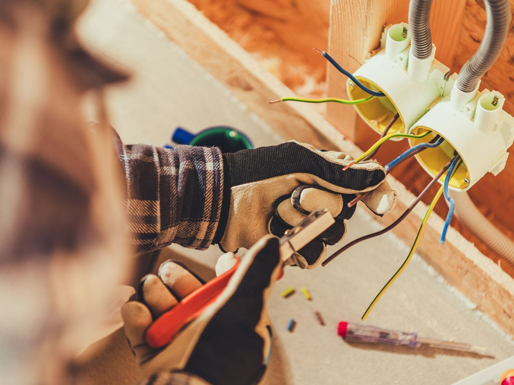 Zoom sur des mains qui remplacent des prises électriques