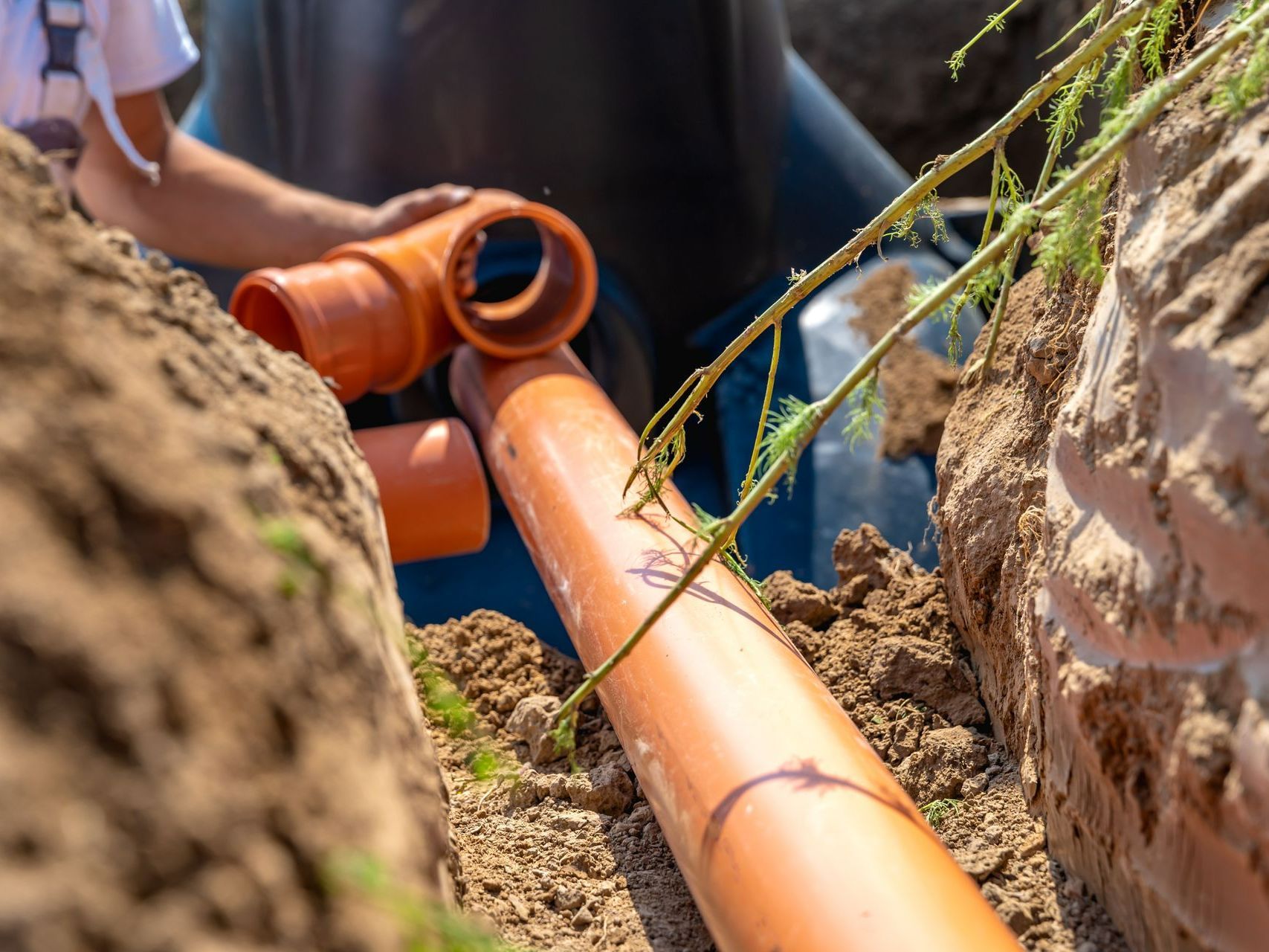 Tuyau de canalisation orange dans la terre