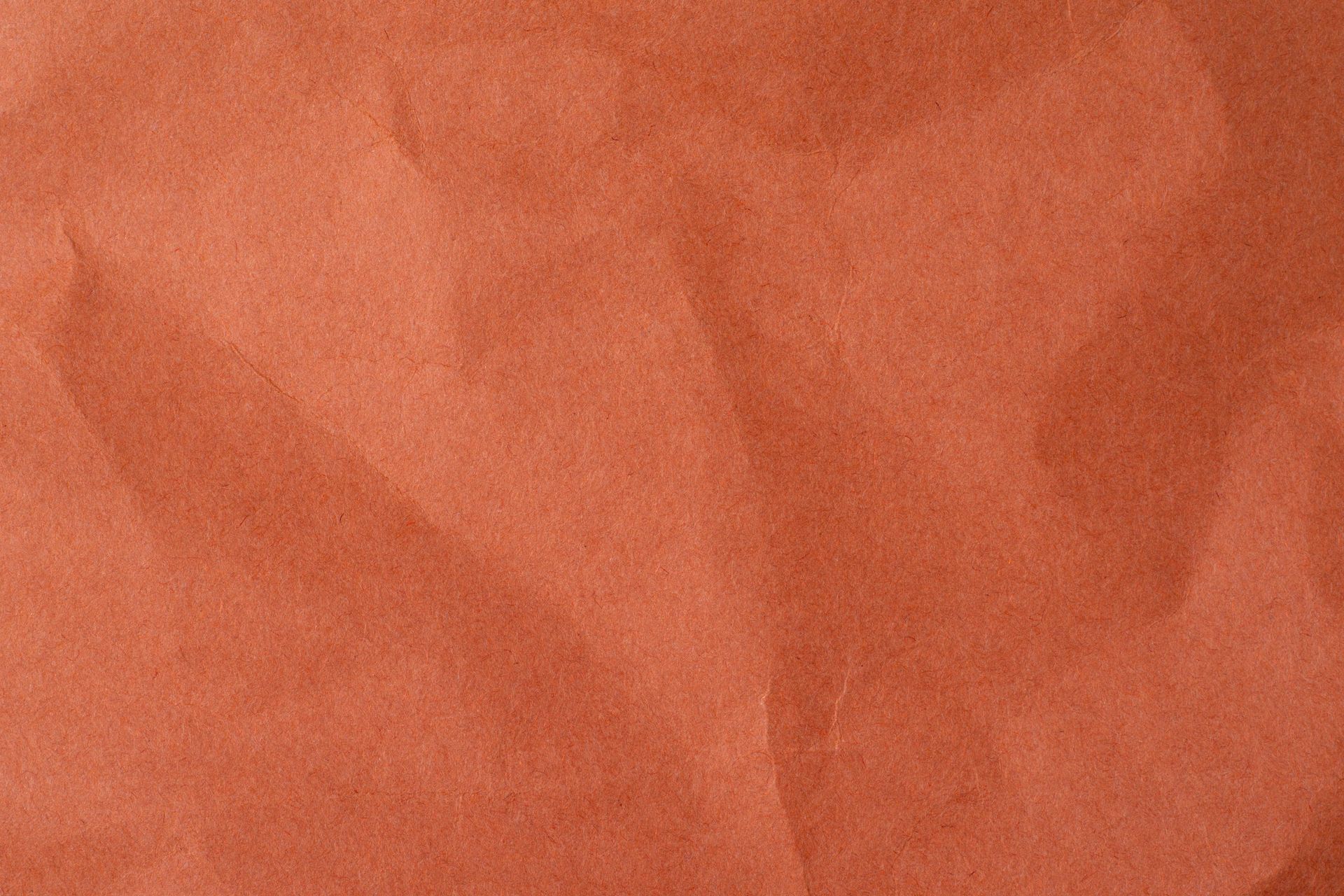 Close-up of crumpled, textured, orange-brown paper.