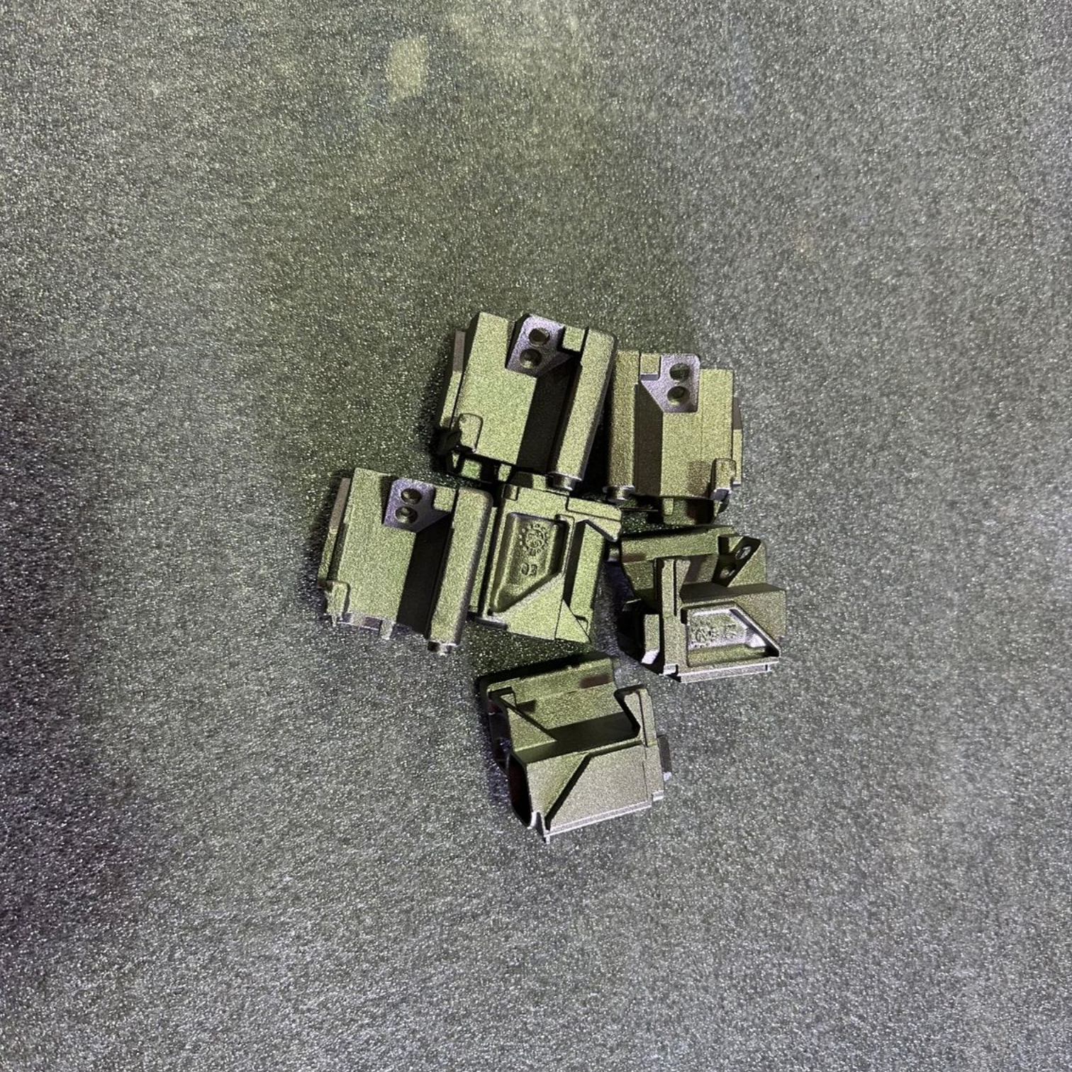 Deux composants en acier inoxydable, l'un mat, l'autre poli, avec des ouvertures en forme d'entonnoir et des tubes incurvés sur le dessus.