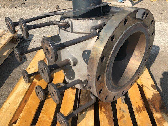 Pièce métallique industrielle de grande taille, comportant une bride proéminente et plusieurs brides plus petites.