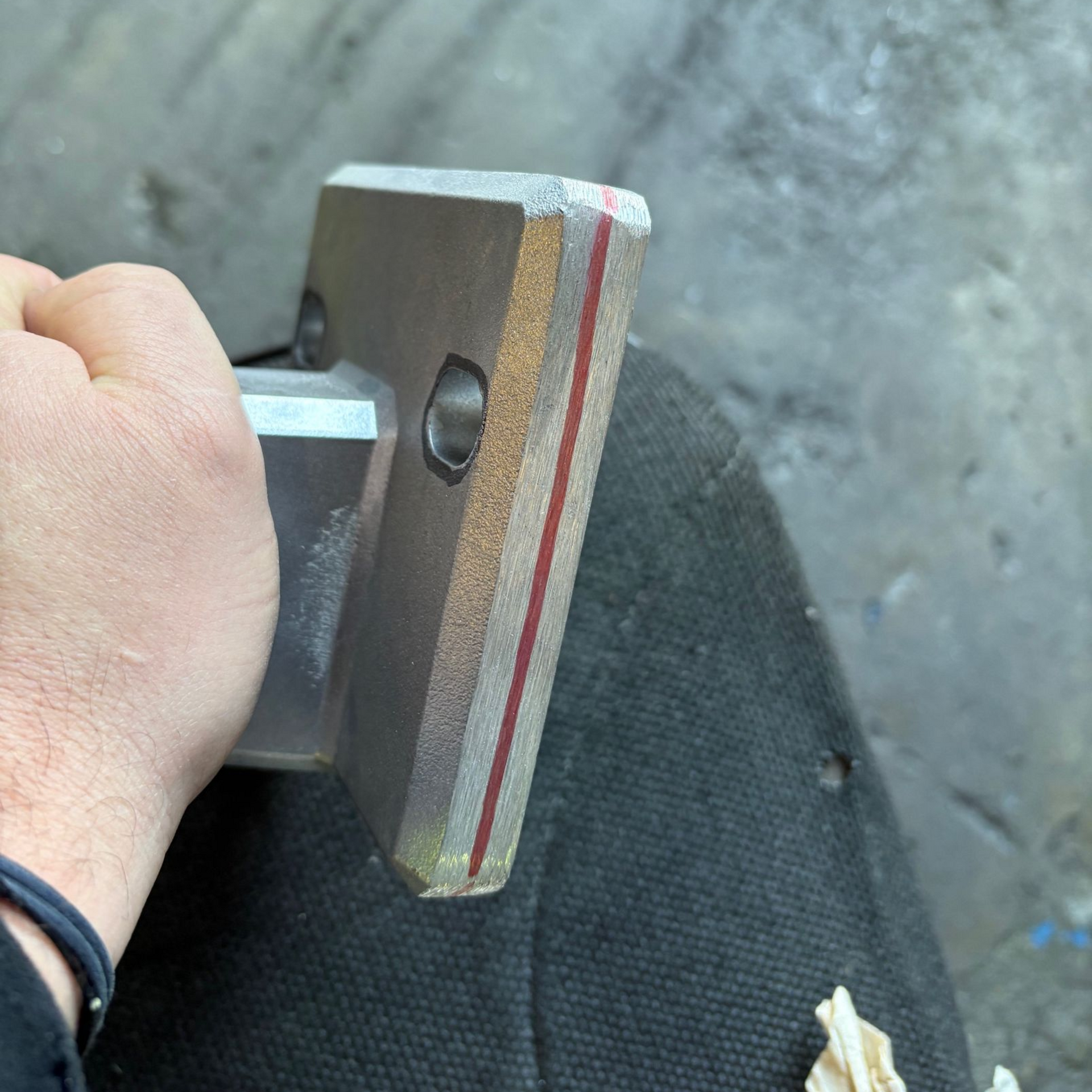 Jante de roue de voiture brillante et polie, de forme circulaire, avec des trous de vis visibles, posée sur une surface.