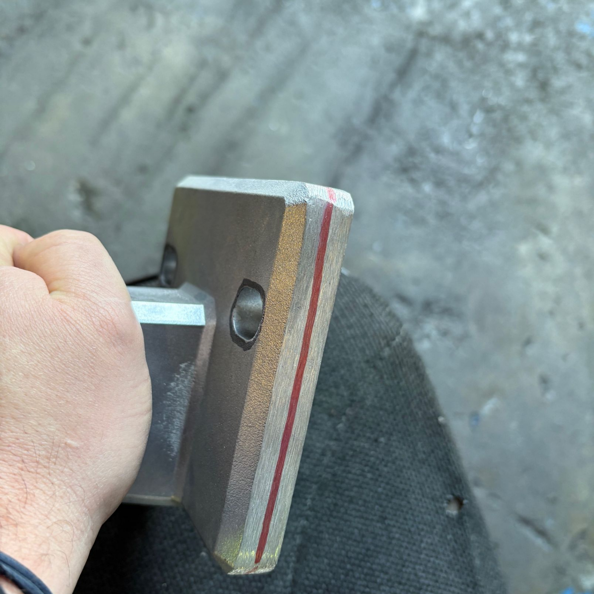 Pièce chromée brillante dans un étui, le doigt pointant vers son bord.