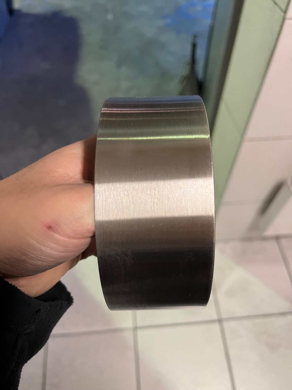 Jante de voiture chromée brillante posée sur une boîte en carton dans un environnement industriel.