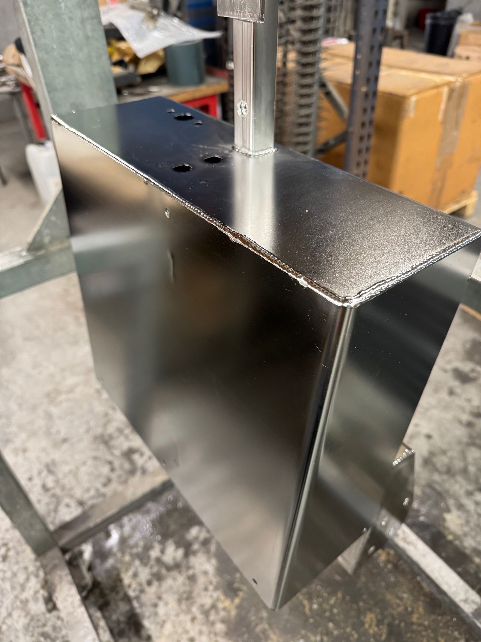 Entrepôt avec porte sectionnelle ouverte, panneau « BREFF d'outillage ». Bardage métallique, chaussée sombre, journée ensoleillée.