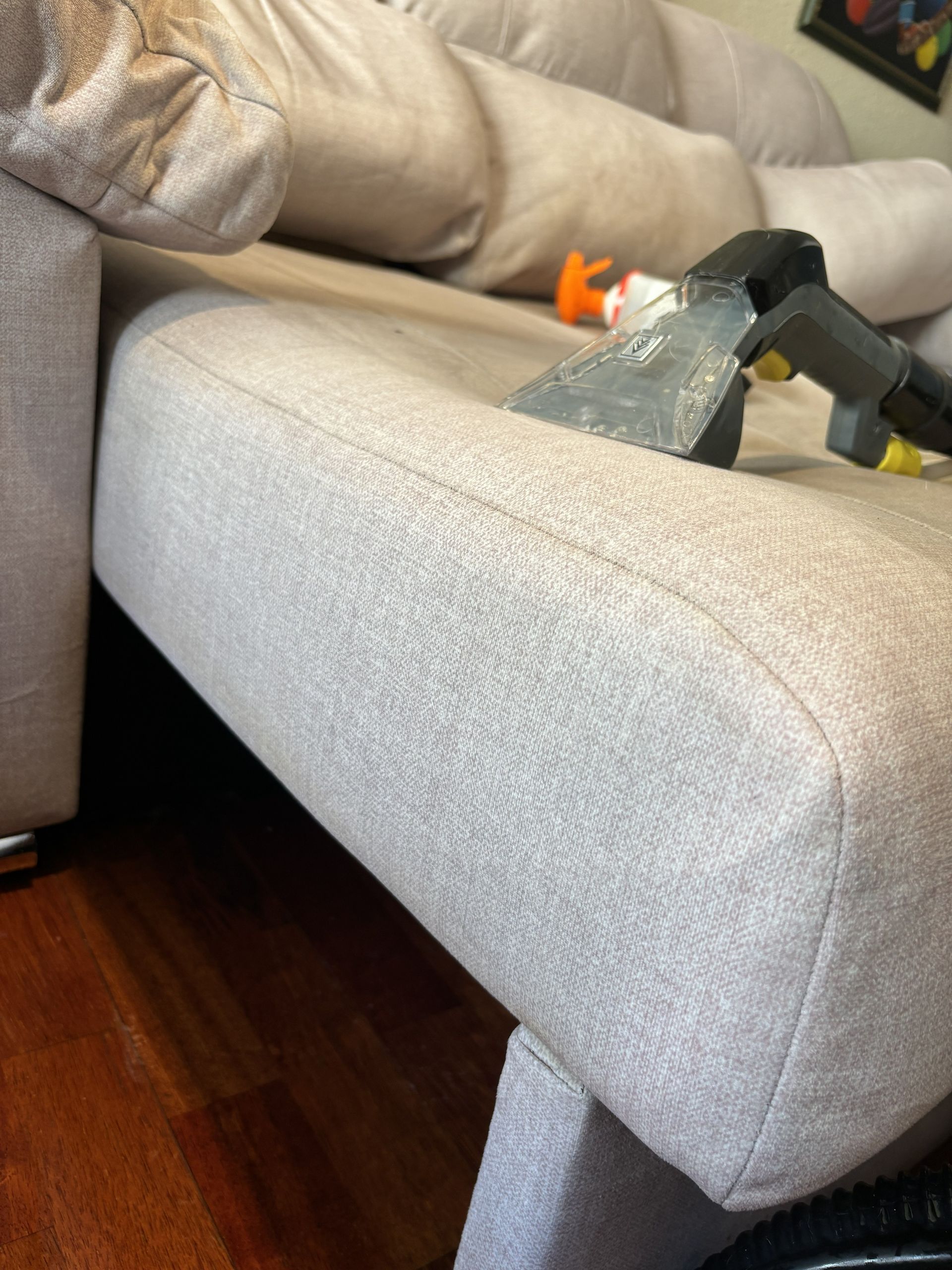 Aspirar un sofá gris claro en una sala de estar.