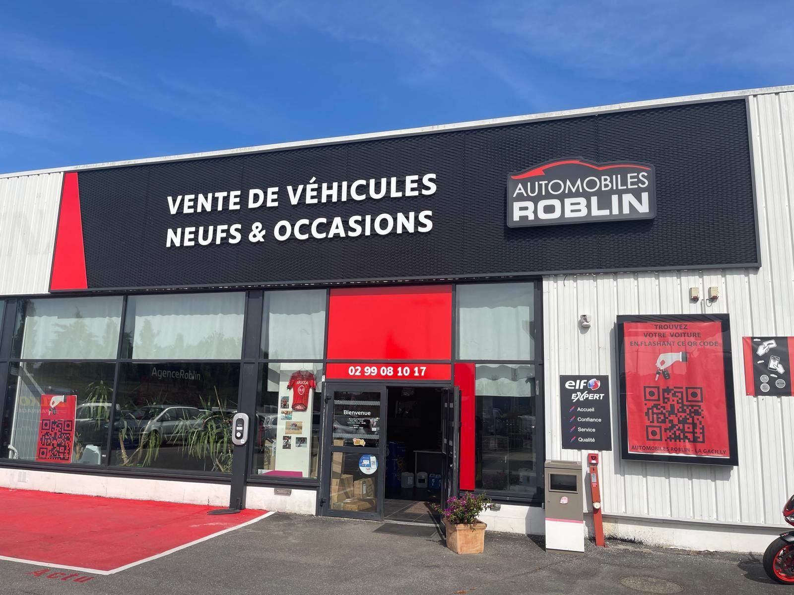 Atelier de réparation automobile blanc et noir. Vue extérieure par une journée ensoleillée.