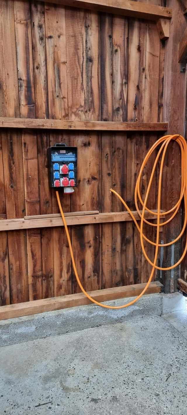 Un mur en bois auquel est fixé un tuyau.