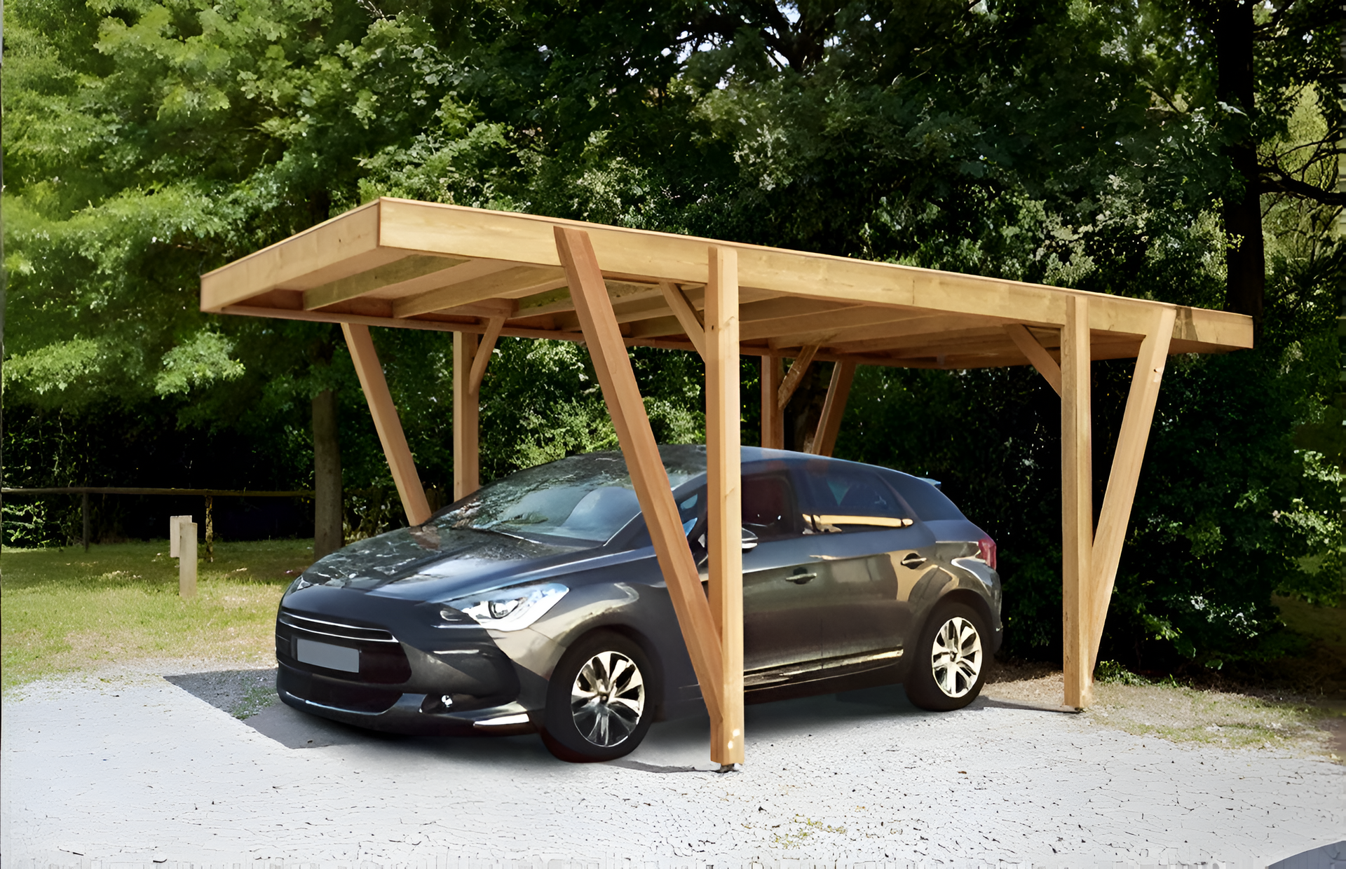 Voiture garée sous un abri en bois. Voiture grise, abri marron clair, extérieur sur gravier.