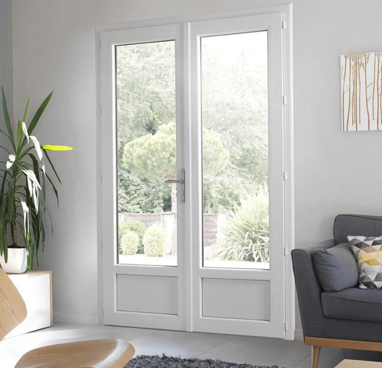 Des portes-fenêtres blanches s'ouvrent sur un jardin luxuriant. 