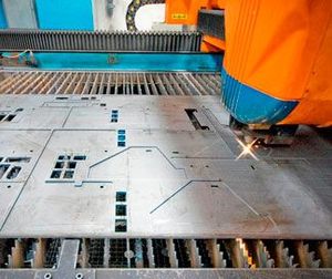 Una máquina está cortando un trozo de metal en una fábrica.