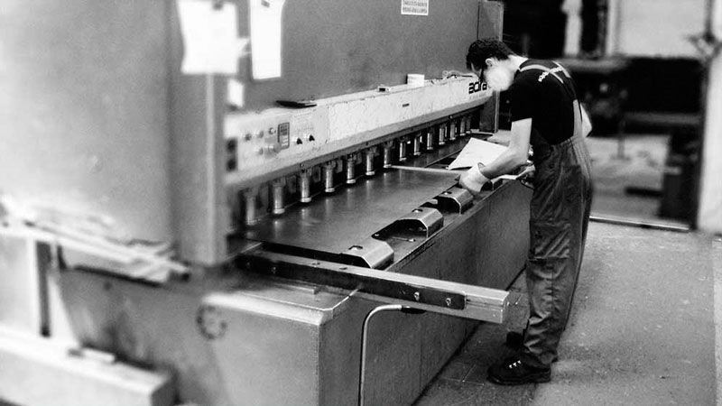 Un hombre está trabajando en una máquina en una fábrica.