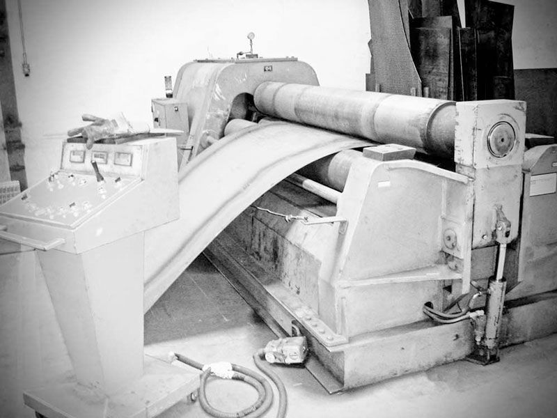 Una fotografía en blanco y negro de una máquina que está enrollando un trozo de metal.