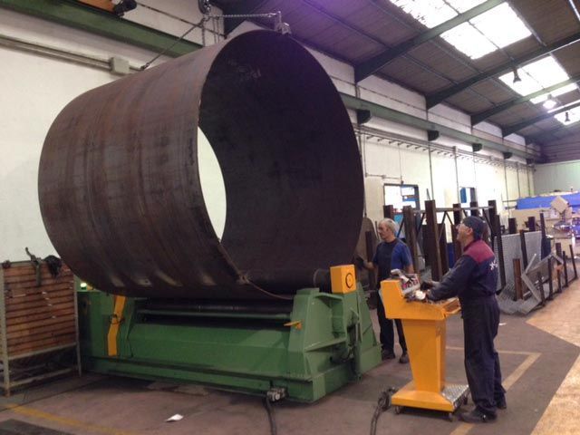 Un hombre está trabajando en una máquina en una fábrica.