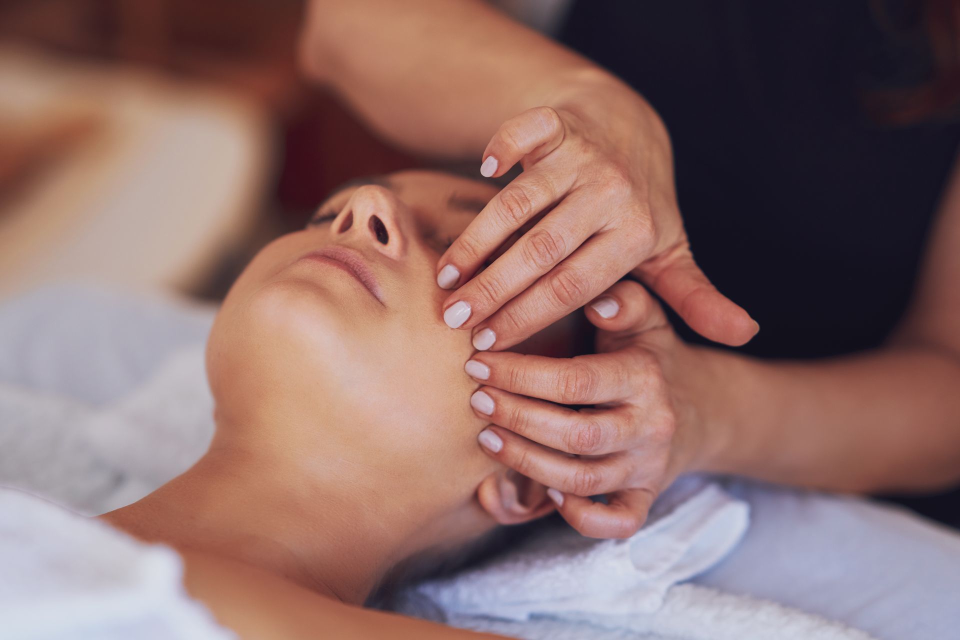 Photo de mains massant un visage de femme