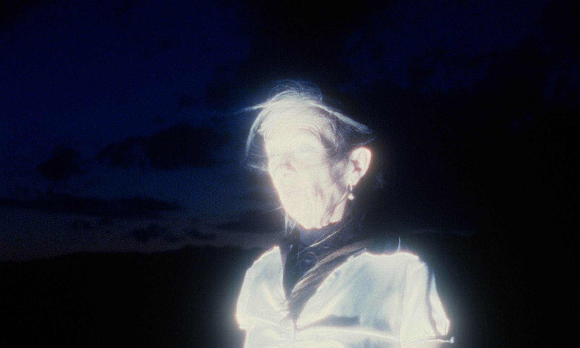 Figura luminosa contra un cielo oscuro. La figura resplandece con un aura blanca.