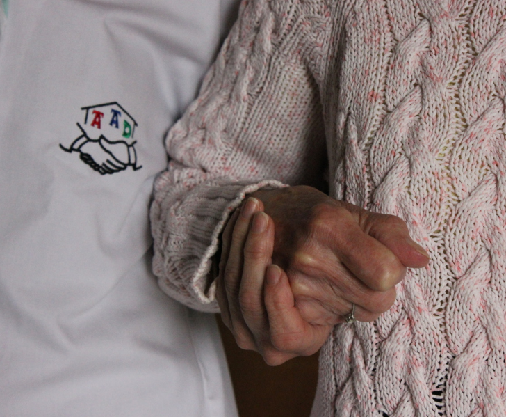 Auxiliaire de vie et senior se tenant la main