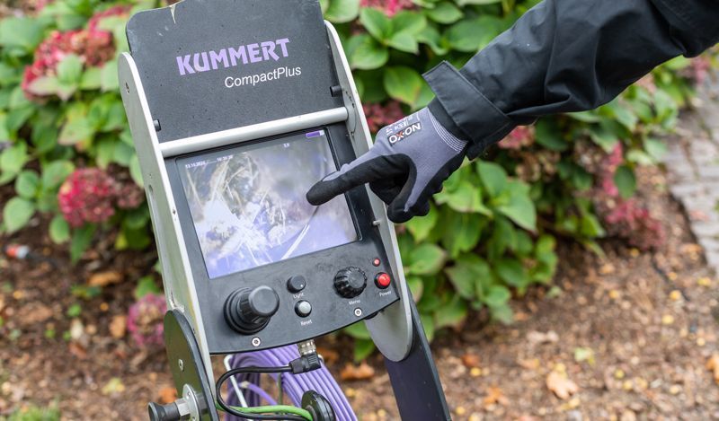 Eine Person zeigt auf den Bildschirm einer Maschine.