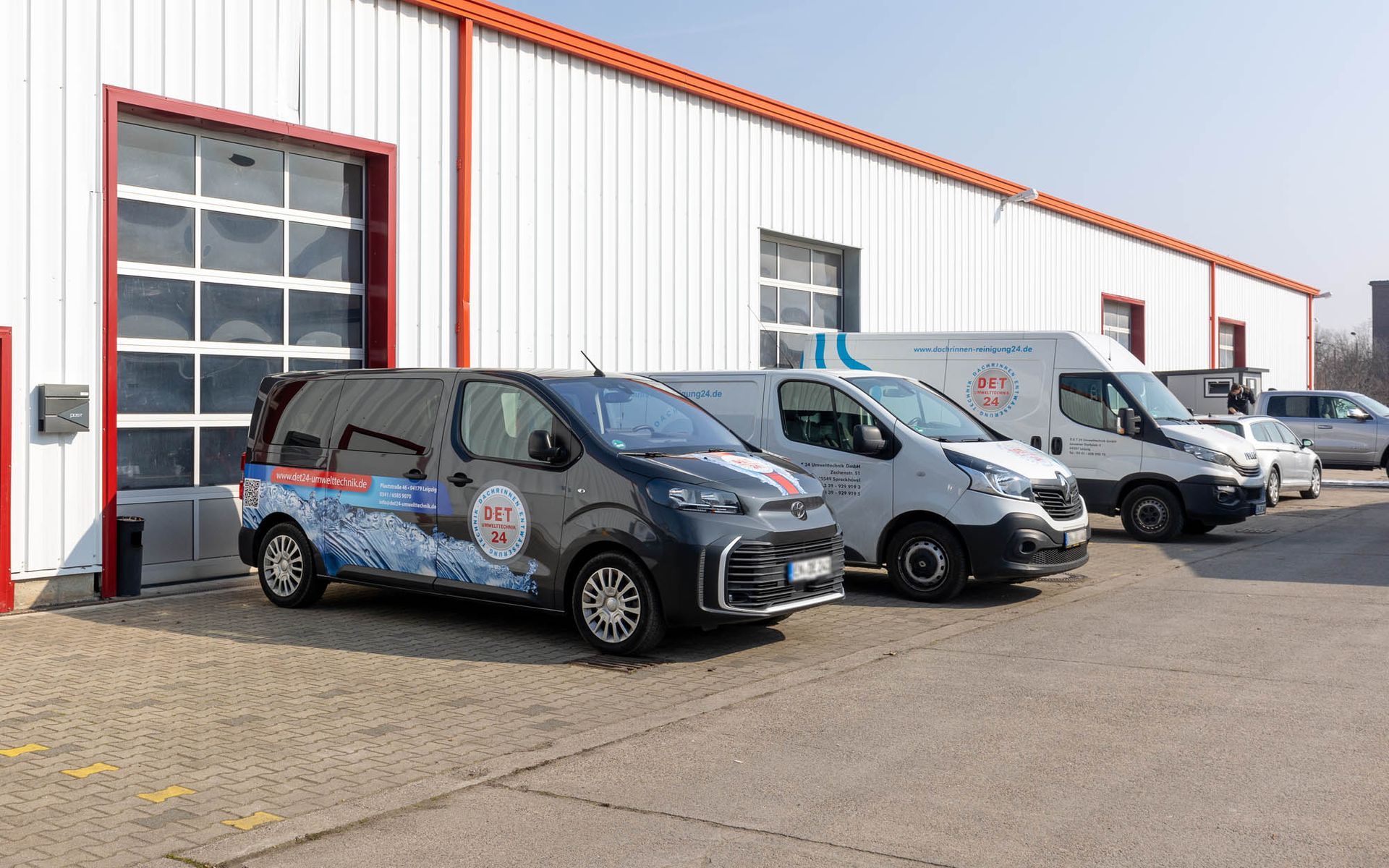 Eine Reihe von Lieferwagen parkt vor einem Gebäude.