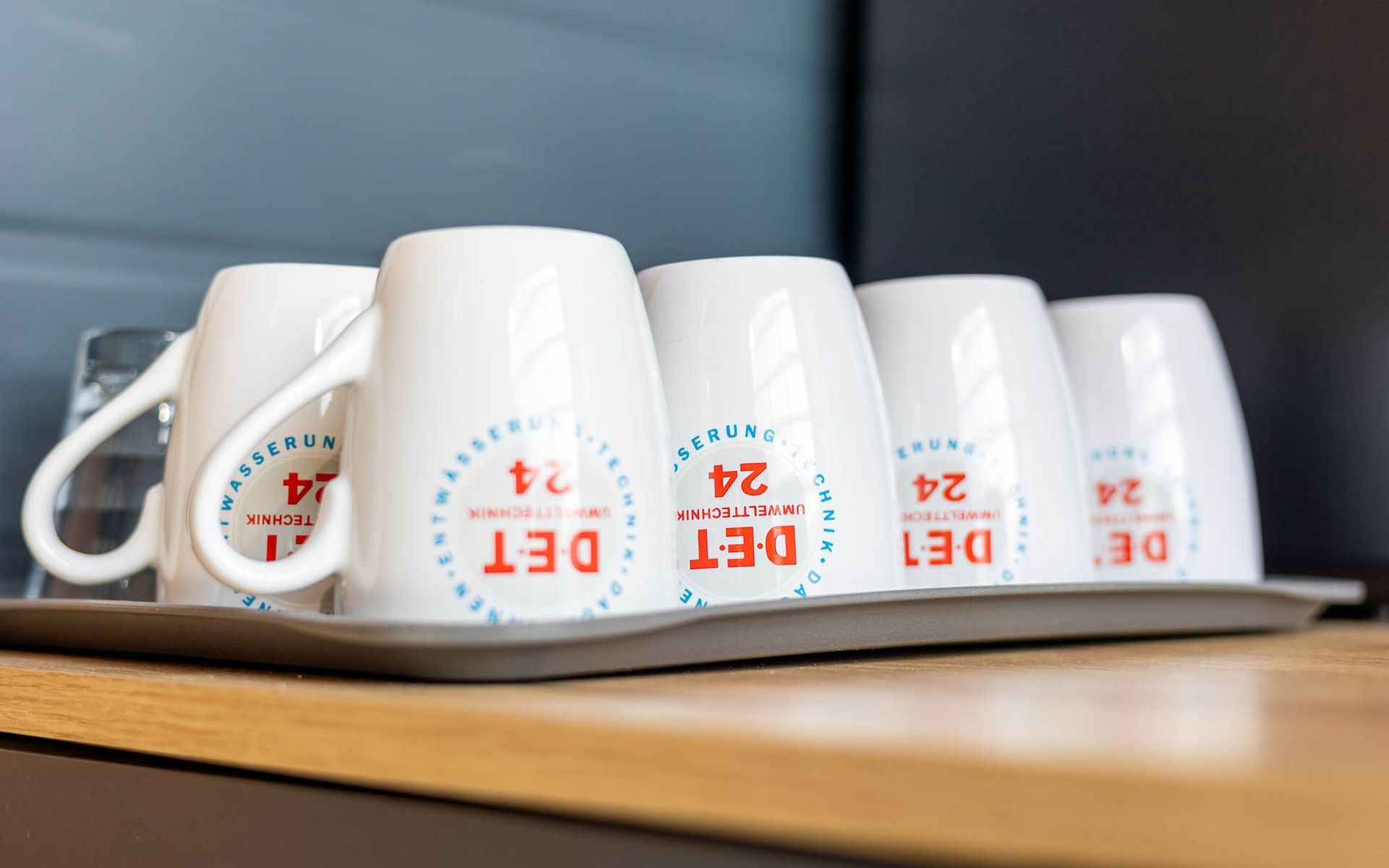 Ein Tablett mit Kaffeetassen auf einem Holztisch.