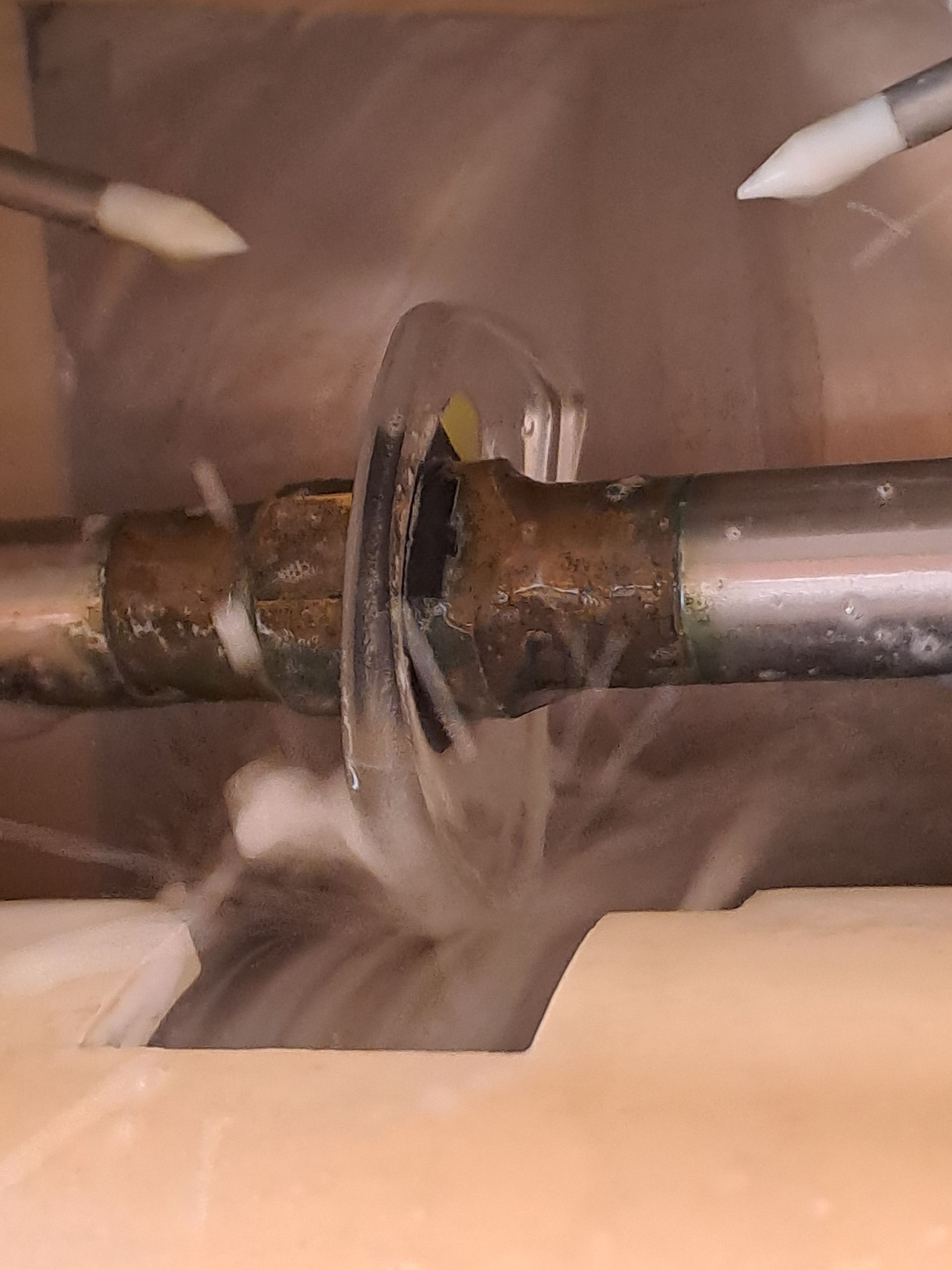 Eine Person schneidet ein Stück Metall mit einer Kreissäge.