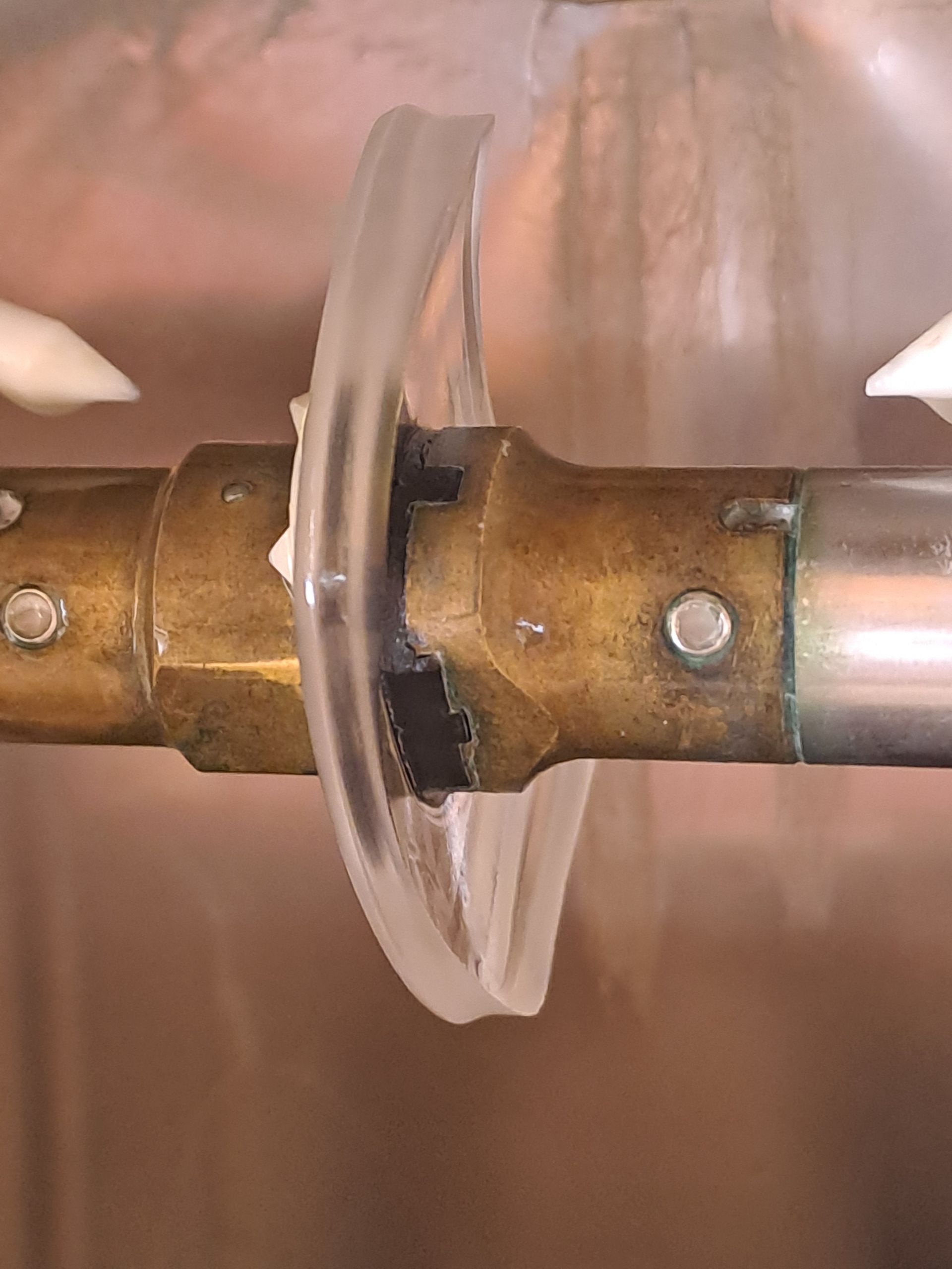 Eine Nahaufnahme eines Messingrohrs mit einem Plastikring darauf.