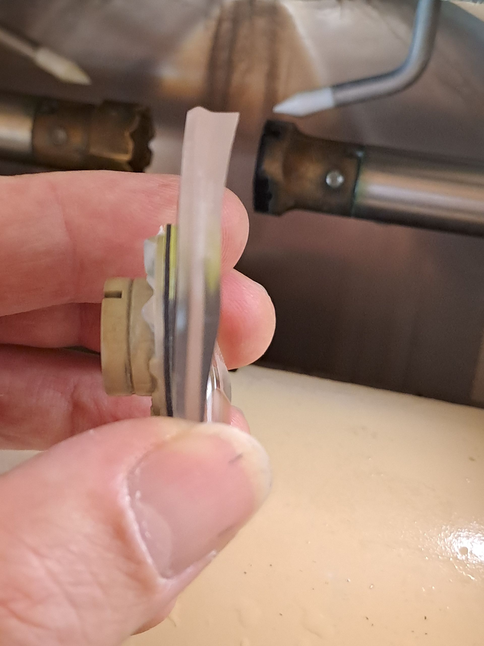 Eine Person hält ein Stück Metall in der Hand.