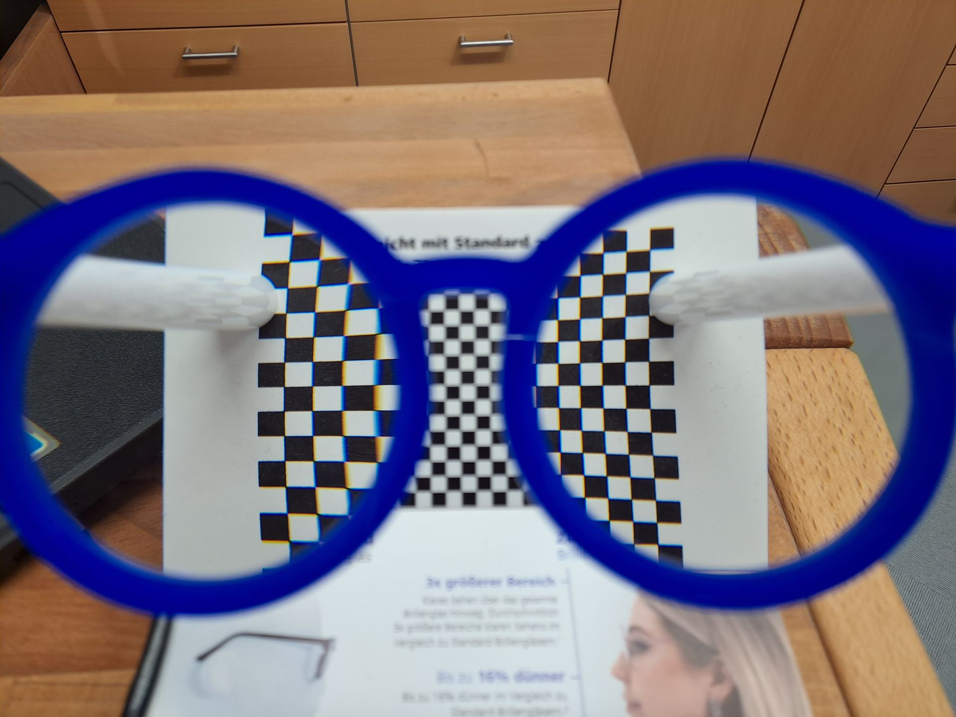 Eine blaue Brille auf kariertem Papier