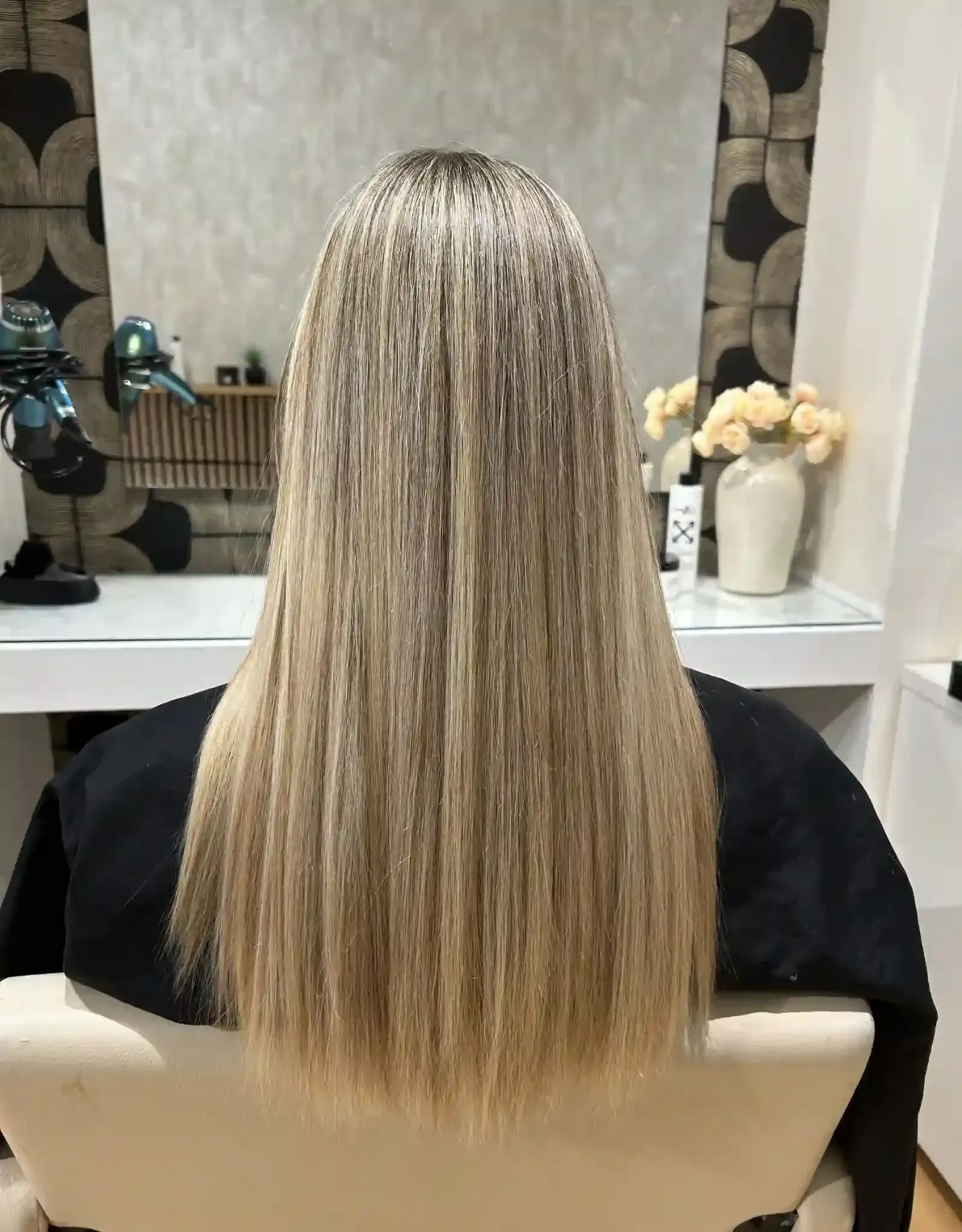 Extensiones de cabello rubio en estilo largo y liso, en una peluquería.
