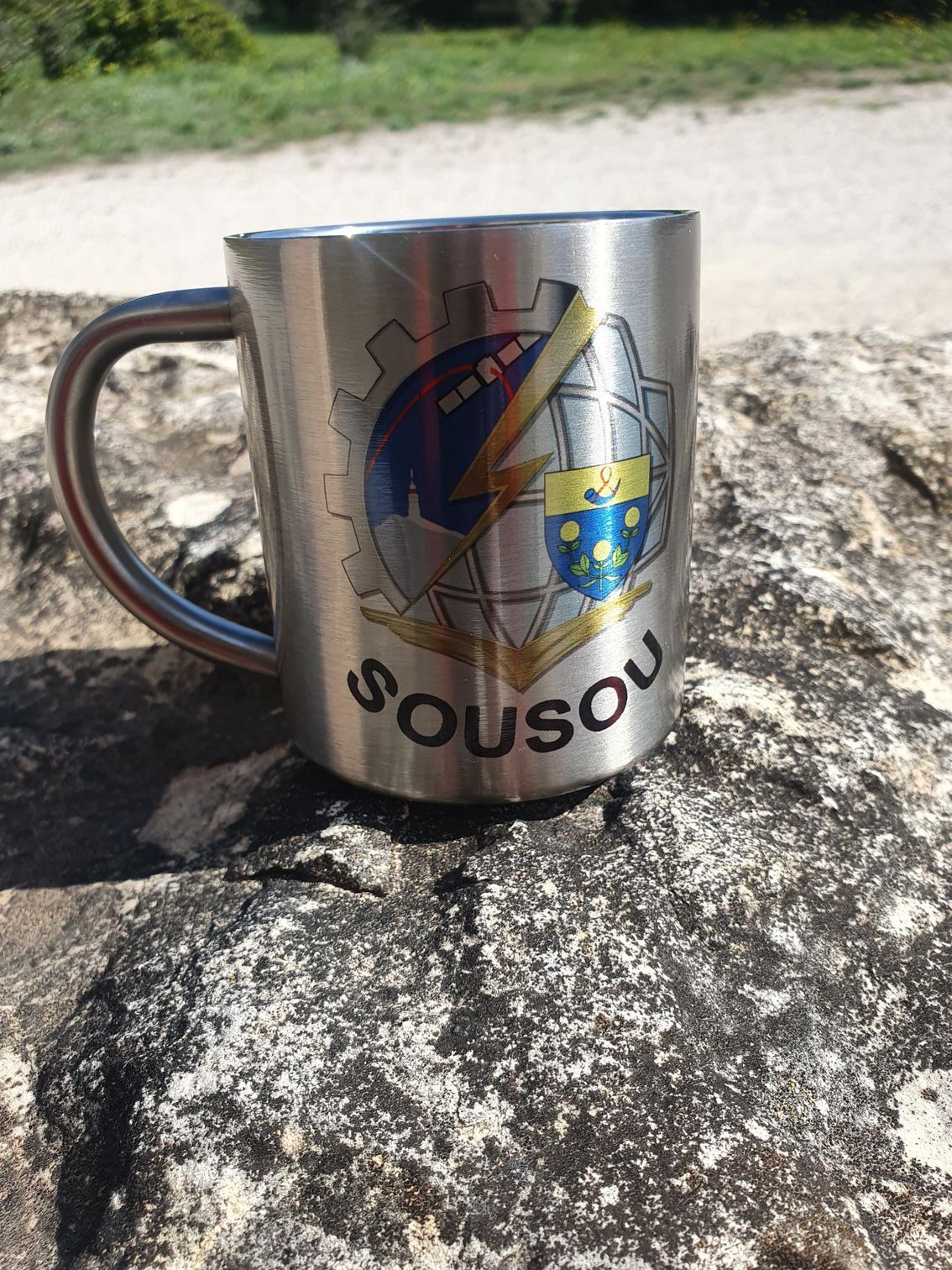 Main d'homme tenant un mug inox