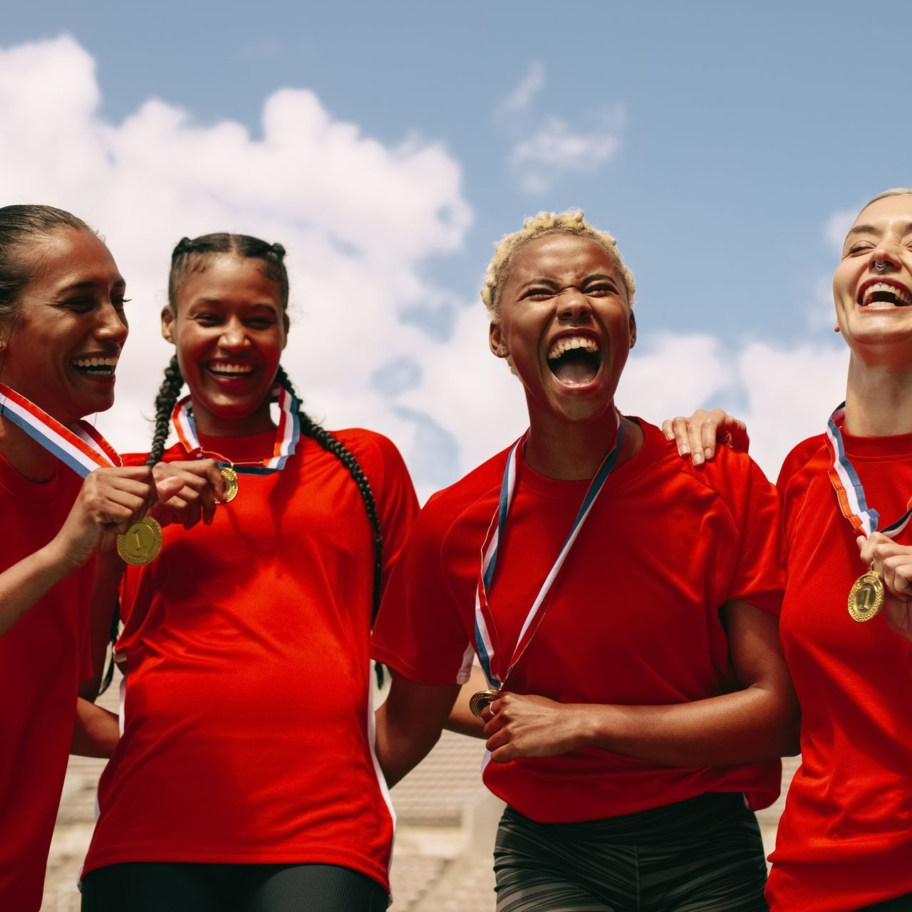 Quatres femmes souriantes avec des médailles