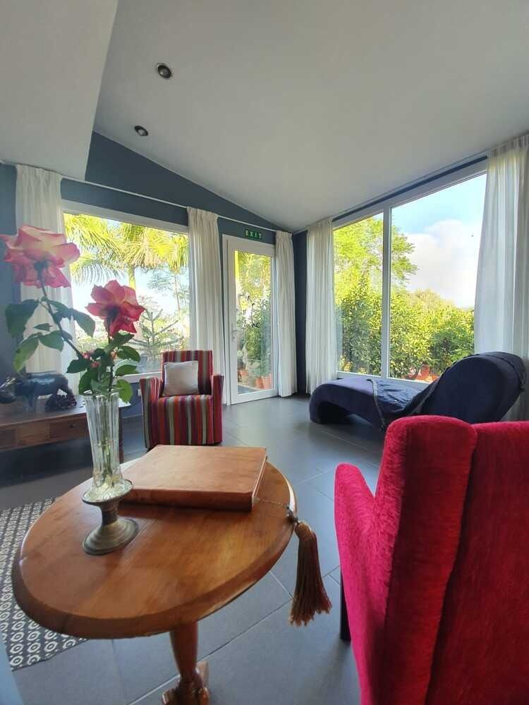 Una sala de estar con una mesa y sillas y un jarrón de flores.