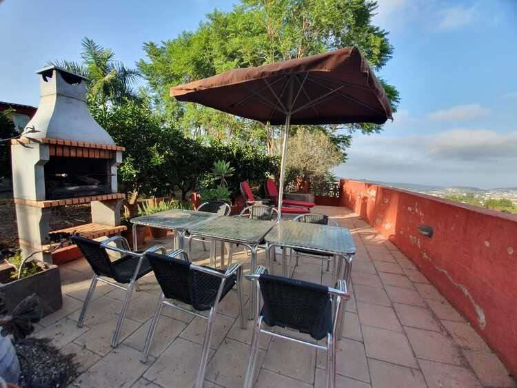 Un patio con una mesa y sillas y una sombrilla.