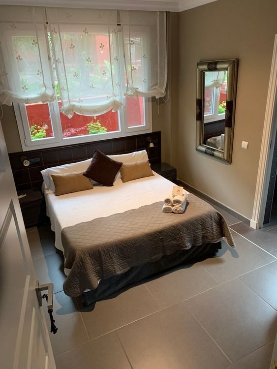 Un dormitorio con una cama grande y un espejo en la pared.