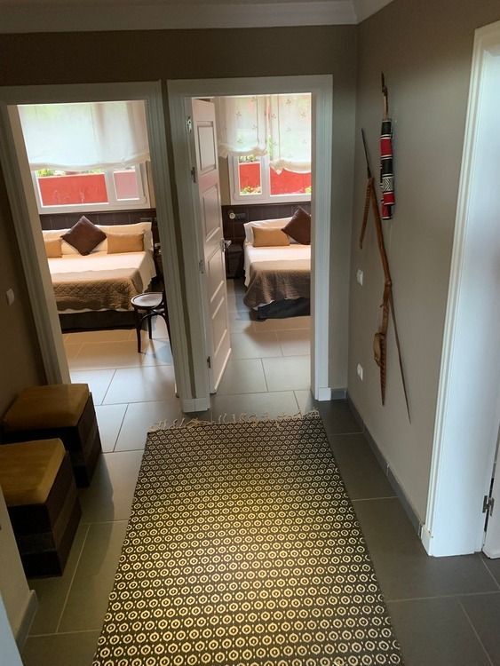 Un pasillo que conduce a un dormitorio con una alfombra en el suelo.