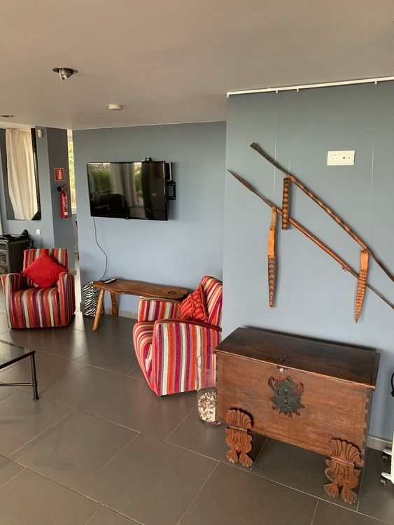 Una sala de estar con una silla a rayas y un baúl.