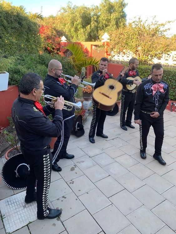 Un grupo de hombres toca instrumentos en un patio.