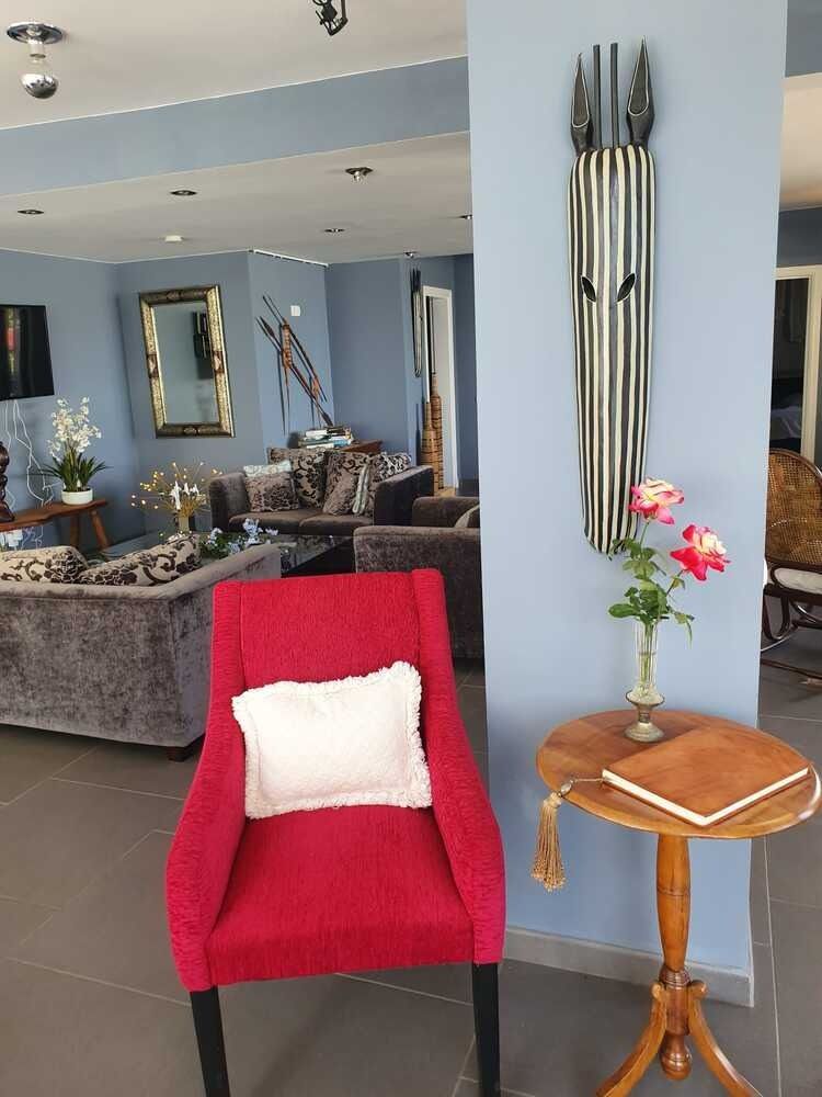 Una sala de estar con una silla roja y una mesa pequeña.